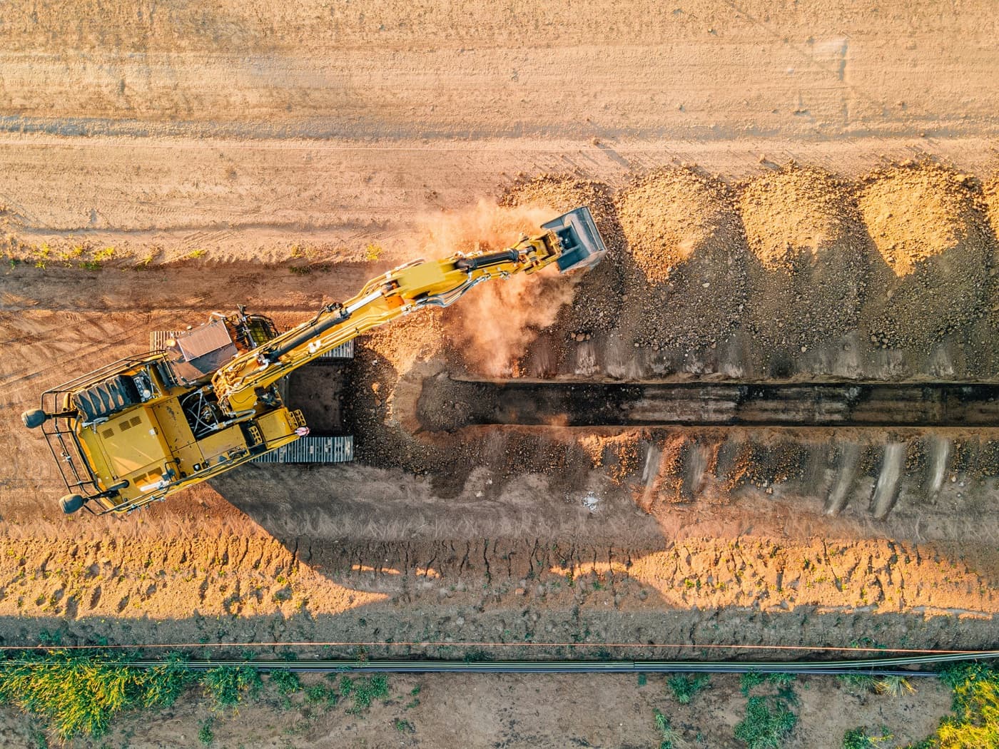 An excavator loading out a trench on a live earthworks job